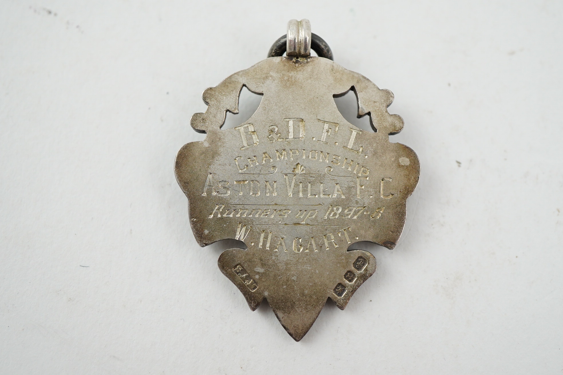 Aston Villa Football Club interest :, a late Victorian silver football medal, inscribed 'B & D.F.L. Championship, Aston Villa F.C. Runners Up 1897/98, W. Hagart [sic]', makers S.A.M., Birmingham, 1897, 44mm, in case of i